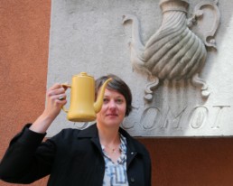 Anne Herbauts, devant l’éditeur Casterman, installé dans les anciens locaux du torréfacteur Jacqmotte Bruxelles. Elle pose avec une cafetière, objet très présent dans l’œuvre de l’artiste qui l’a même transformée en éléphant. | ANNE-FLORE HERVÉ